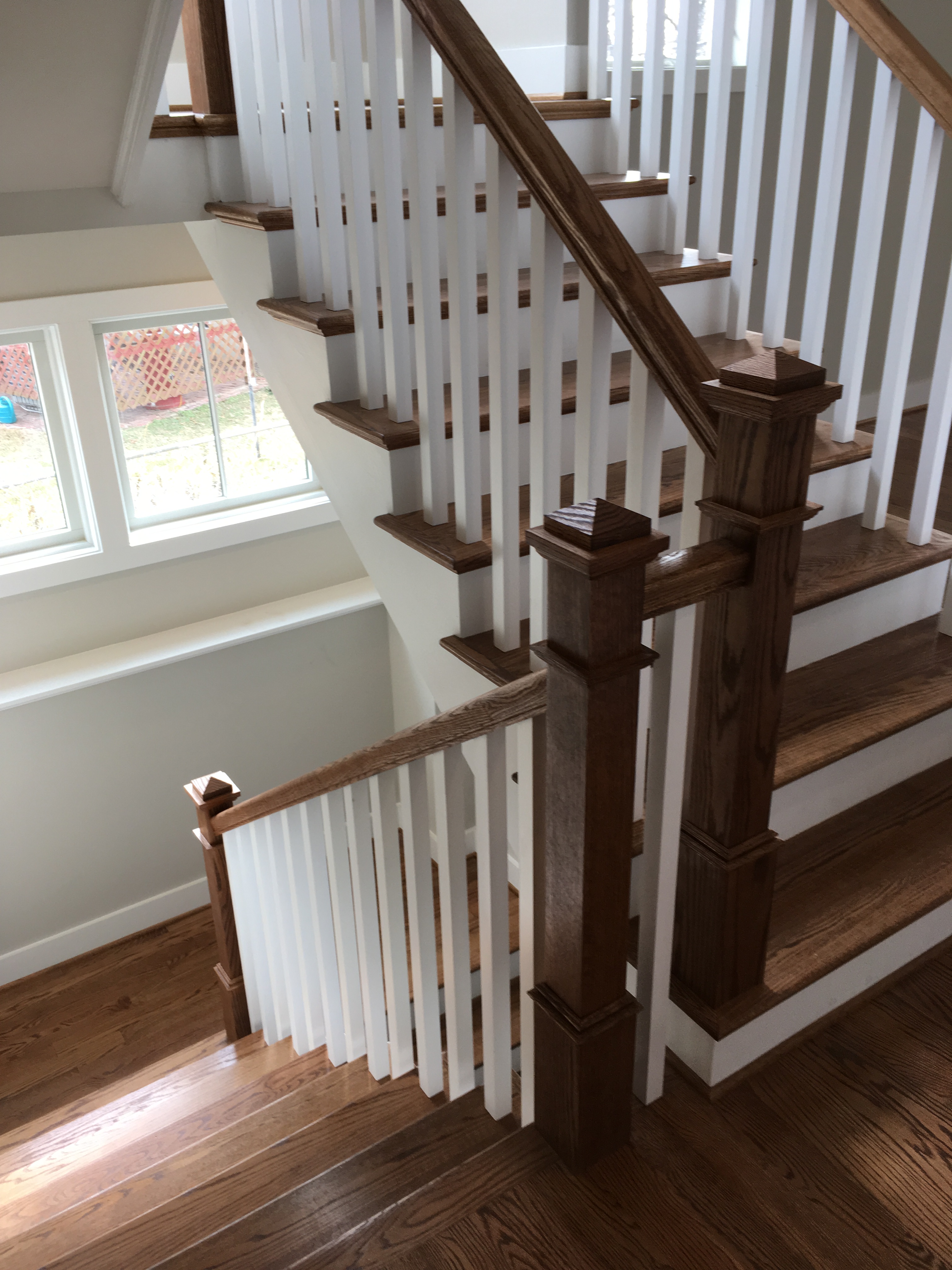 dark wood staircase and railings with white balusters